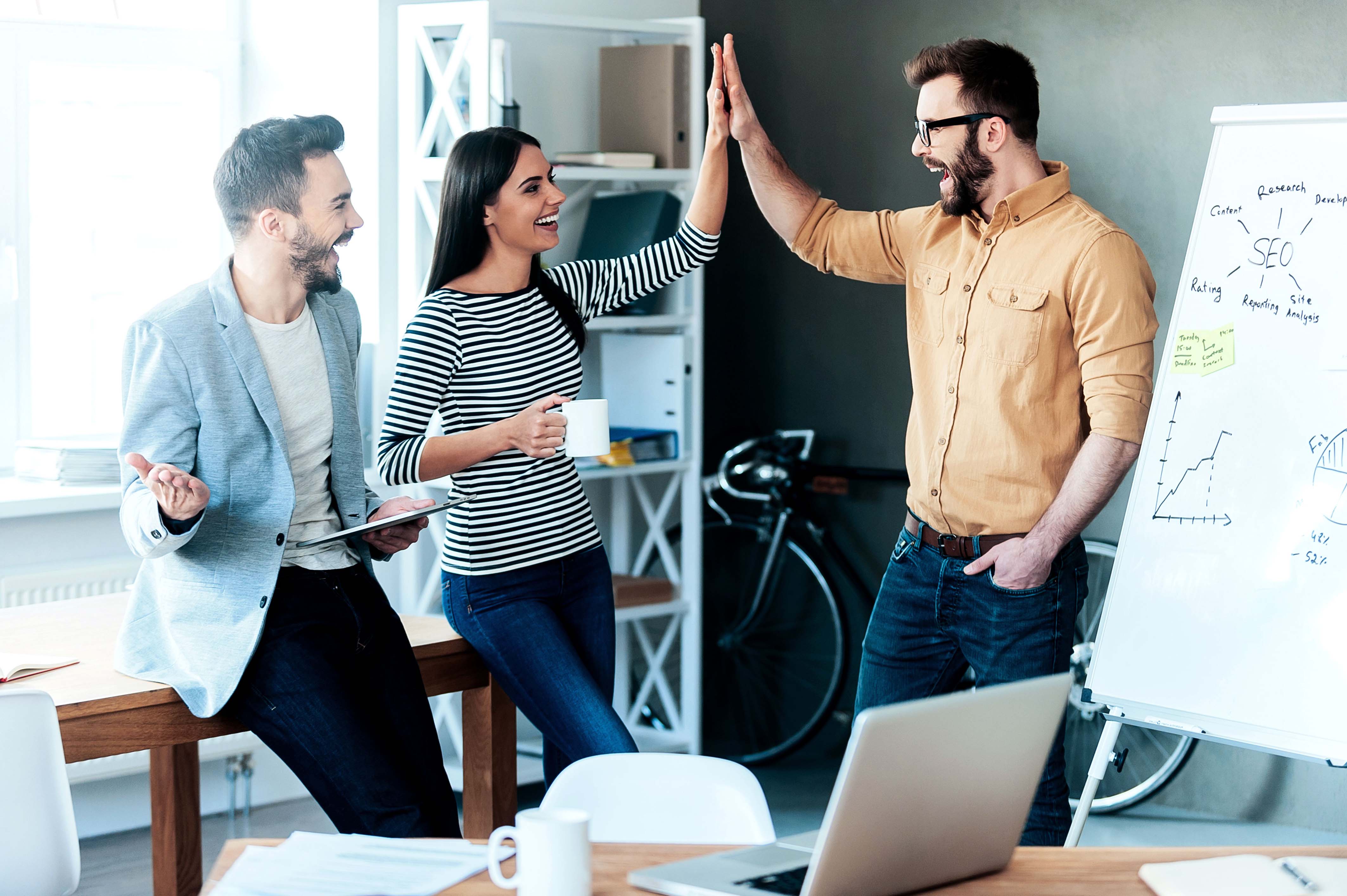 Jóvenes trabajadores celebrando en el trabajo